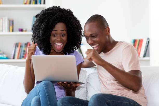 African american couple shopping online with computer indoors at home